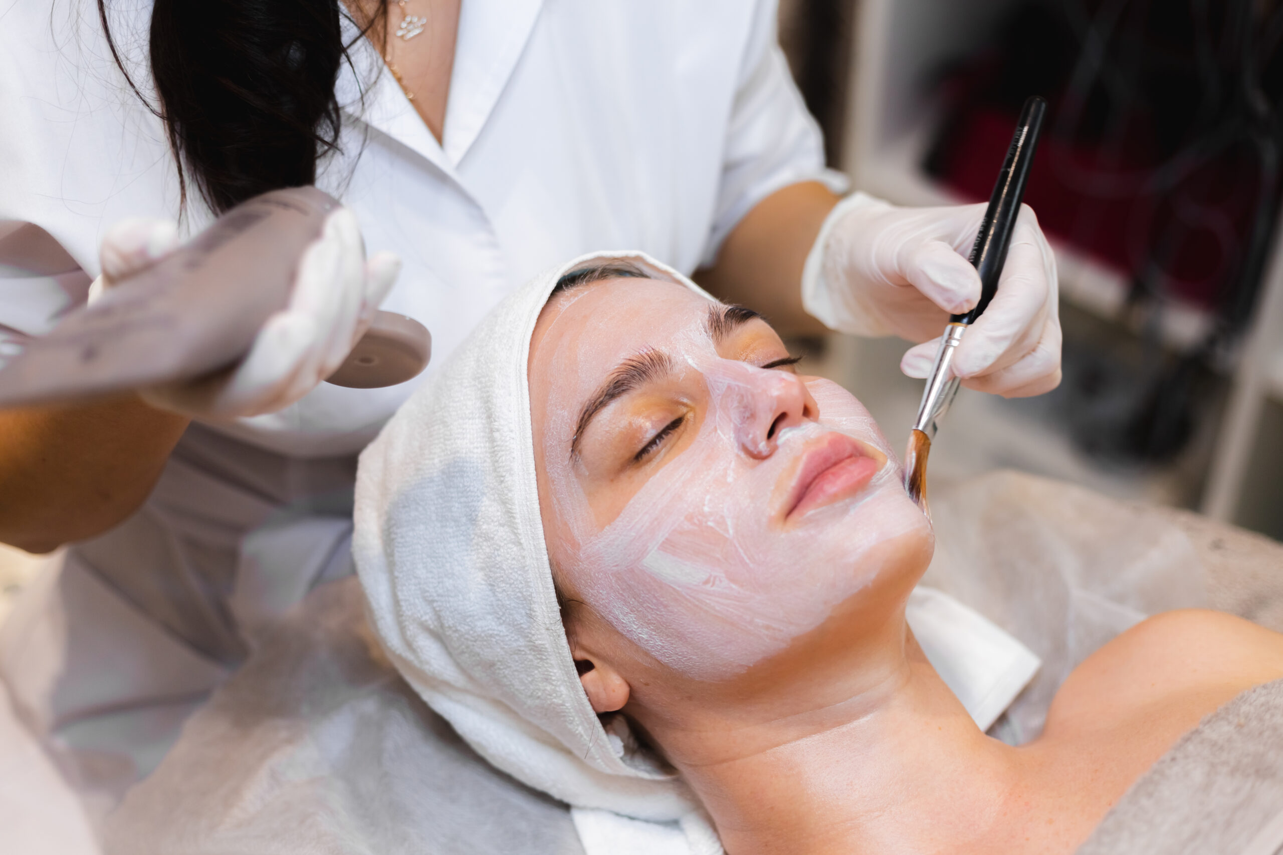 Beautician With Brush Applies White Moisturizing Mask Face Young Girl Client Spa Beauty Salon